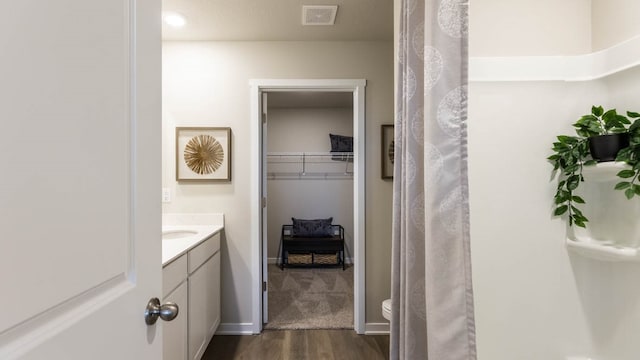 bathroom with hardwood / wood-style flooring, vanity, and toilet