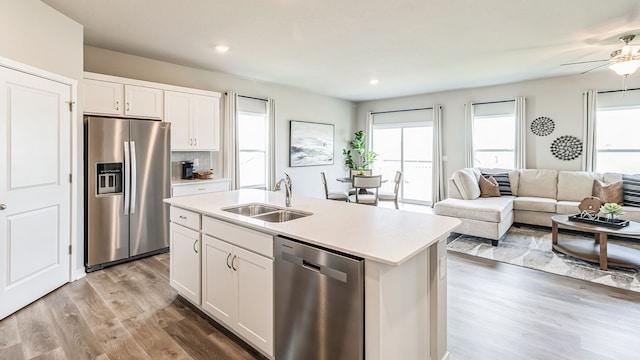 kitchen featuring a kitchen island with sink, sink, white cabinets, and stainless steel appliances