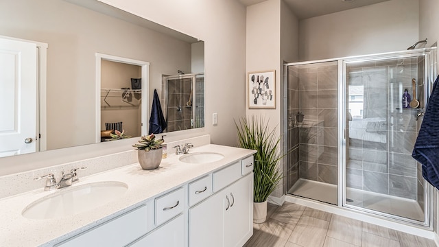 bathroom with tile patterned flooring, vanity, and walk in shower