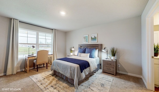 bedroom featuring light colored carpet and a textured ceiling