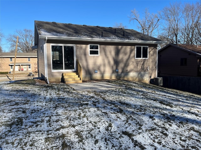 snow covered house with central air condition unit