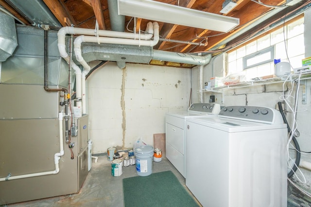 washroom featuring washer and dryer, heating unit, and laundry area