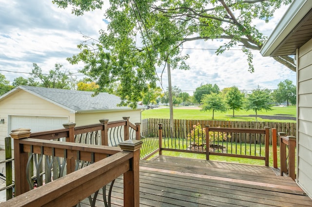 wooden deck with a garage and a lawn