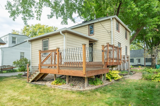 rear view of house with a wooden deck and a yard