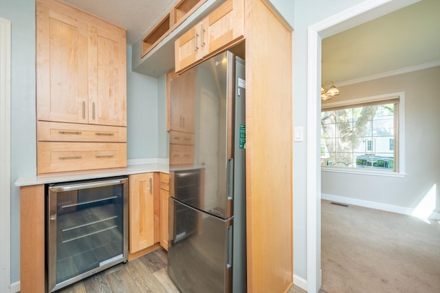 kitchen featuring visible vents, wine cooler, light brown cabinetry, light countertops, and freestanding refrigerator