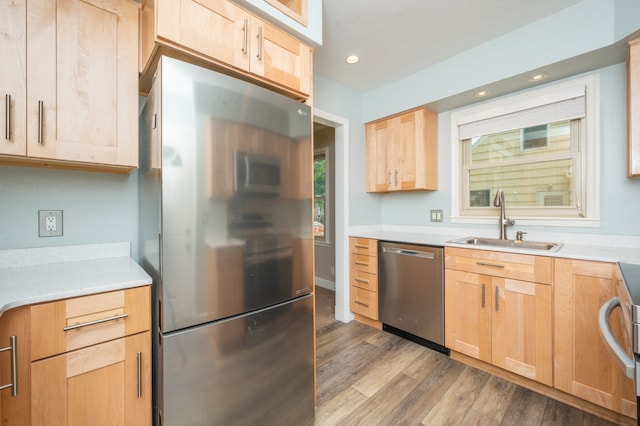 kitchen featuring light brown cabinetry, light hardwood / wood-style floors, appliances with stainless steel finishes, and sink