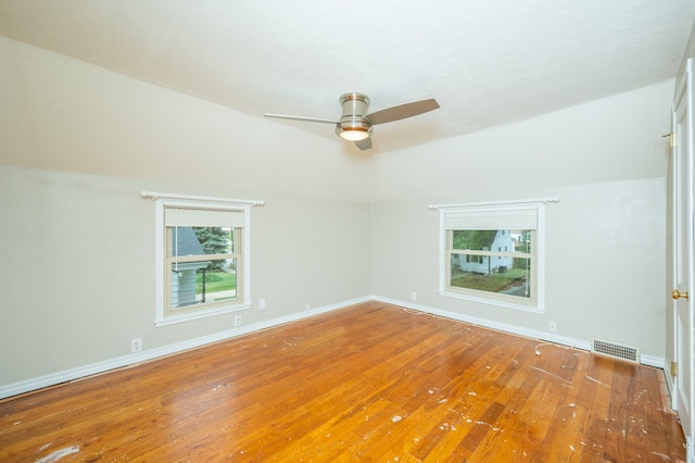 empty room with lofted ceiling, ceiling fan, and hardwood / wood-style flooring