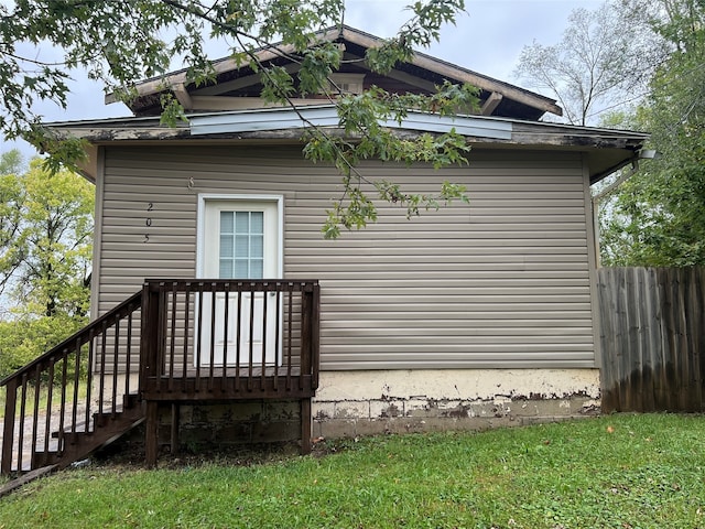 view of property exterior featuring a deck and a lawn