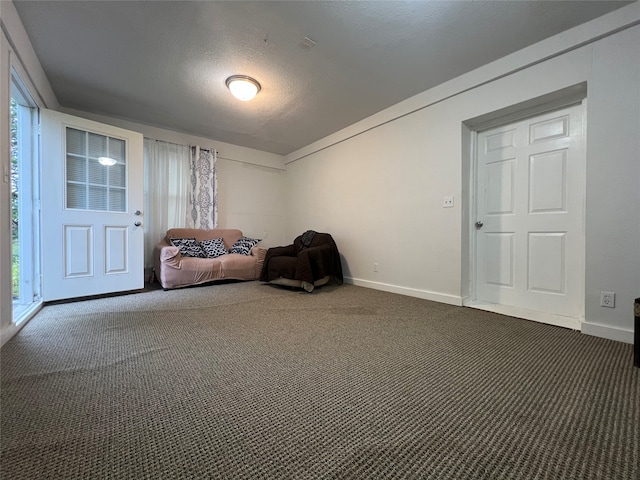 unfurnished room with dark carpet and a textured ceiling