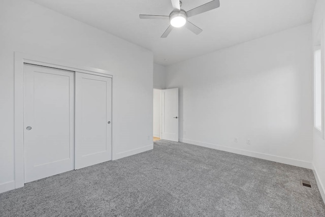 unfurnished bedroom featuring carpet flooring, ceiling fan, and a closet