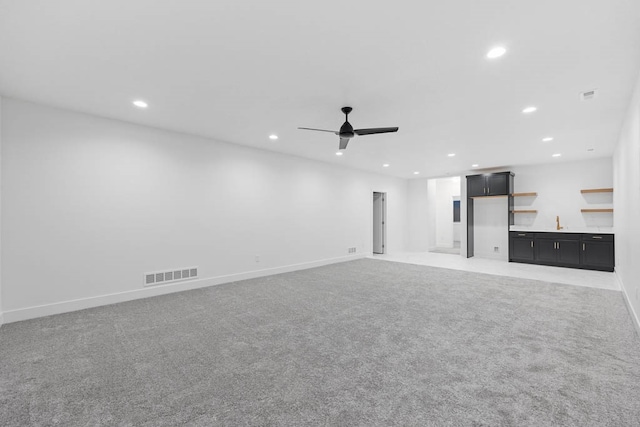 unfurnished living room featuring carpet floors, a fireplace, and ceiling fan