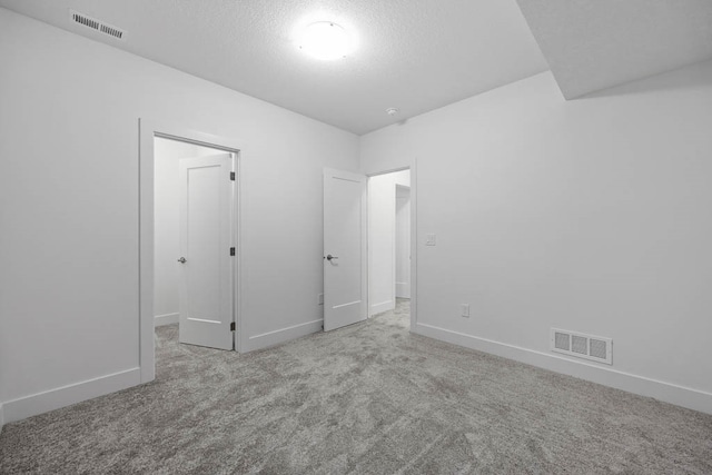 carpeted spare room with a textured ceiling