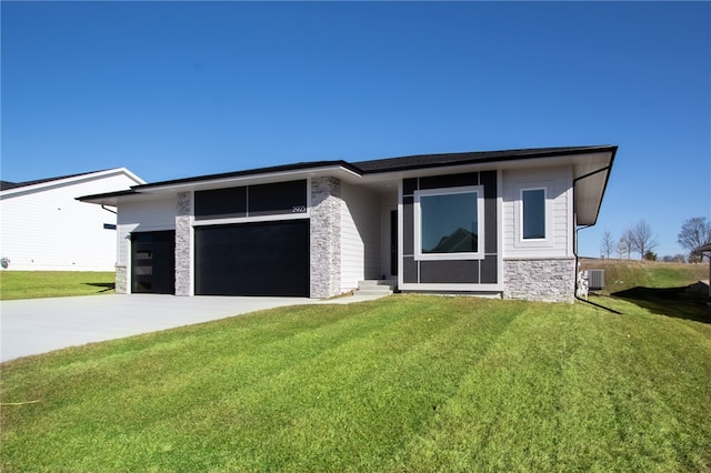 prairie-style house with a garage, central AC, and a front yard