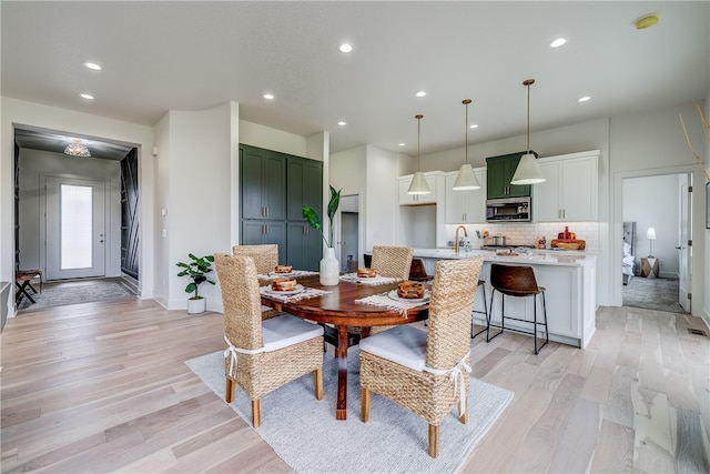 dining space with light wood-type flooring and sink