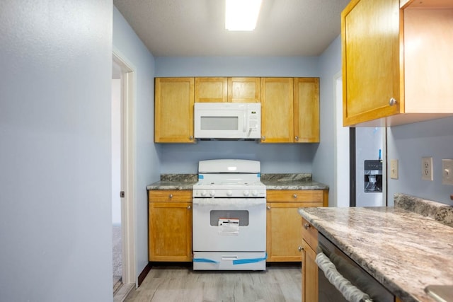 kitchen with white appliances and light hardwood / wood-style flooring