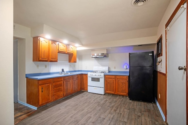 kitchen featuring white stove, hardwood / wood-style flooring, sink, and black refrigerator