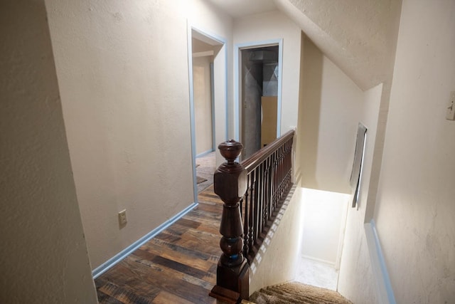 stairs featuring lofted ceiling and hardwood / wood-style floors