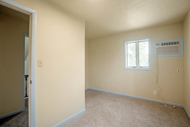 carpeted spare room featuring a textured ceiling and a wall unit AC