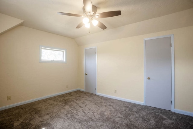 carpeted spare room featuring vaulted ceiling and ceiling fan