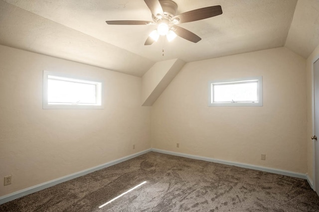 additional living space with carpet floors, vaulted ceiling, ceiling fan, and a wealth of natural light