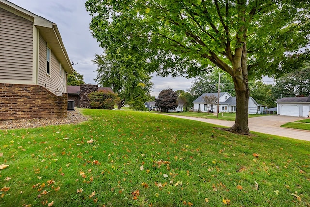 view of yard featuring cooling unit, a garage, and an outbuilding