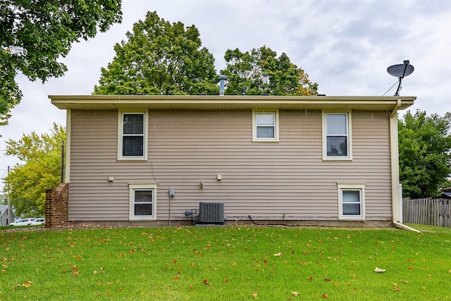 back of property featuring central AC and a yard