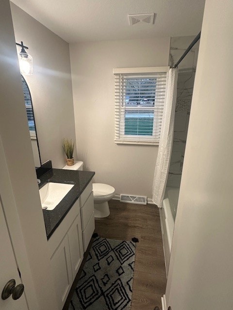 full bathroom featuring toilet, hardwood / wood-style floors, shower / bath combo, and vanity