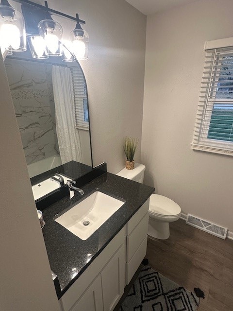 bathroom featuring vanity, a shower with shower curtain, wood-type flooring, and toilet