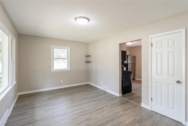 unfurnished room featuring a textured ceiling and hardwood / wood-style flooring