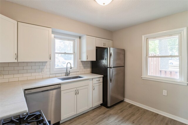 kitchen with white cabinetry, appliances with stainless steel finishes, a healthy amount of sunlight, and sink