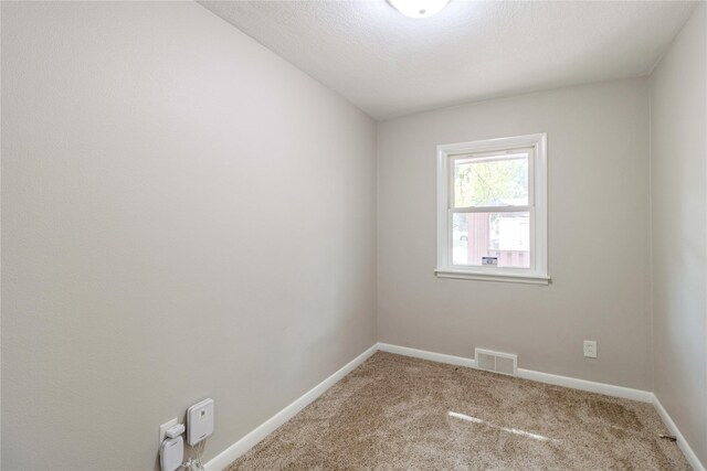 unfurnished room with a textured ceiling and carpet floors