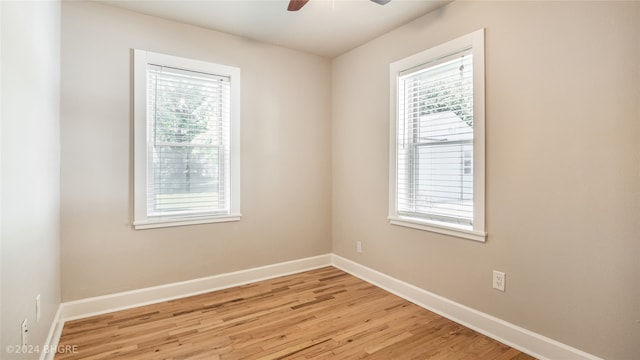 spare room with ceiling fan, a healthy amount of sunlight, and light wood-type flooring