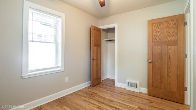 unfurnished bedroom with ceiling fan, a closet, and light wood-type flooring