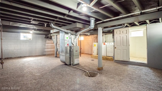 basement featuring carpet flooring, heating unit, electric water heater, and washing machine and clothes dryer