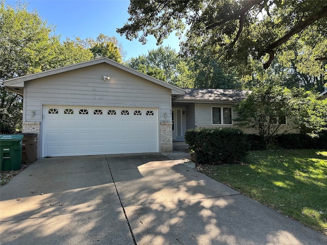 single story home featuring a garage and a front lawn