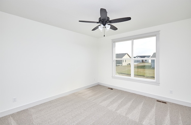 carpeted spare room featuring ceiling fan