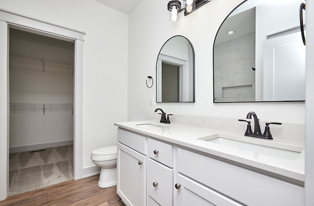 bathroom featuring walk in shower, hardwood / wood-style flooring, vanity, and toilet