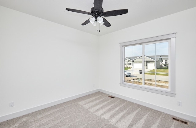 carpeted empty room featuring ceiling fan