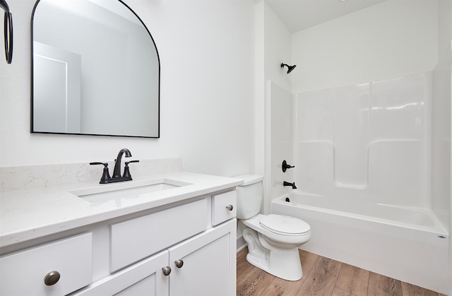 full bathroom with wood-type flooring, vanity, bathtub / shower combination, and toilet