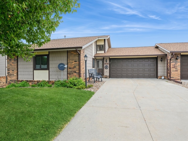 ranch-style house featuring a garage and a front lawn