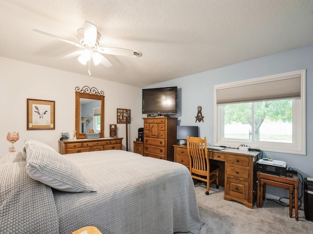 carpeted bedroom with ceiling fan, vaulted ceiling, and a textured ceiling