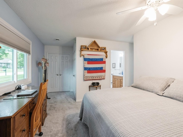 carpeted bedroom with ceiling fan, a closet, and a textured ceiling