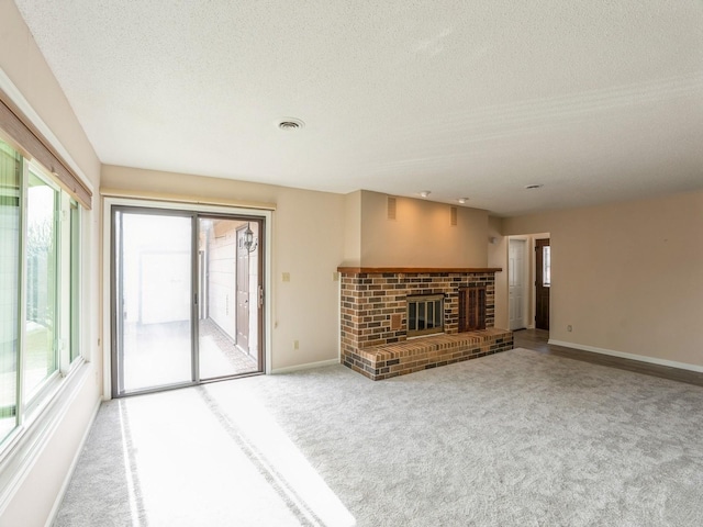 unfurnished living room with a fireplace, a textured ceiling, and carpet flooring