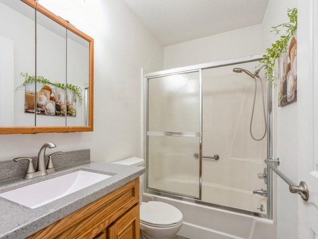 full bathroom featuring toilet, vanity, and bath / shower combo with glass door