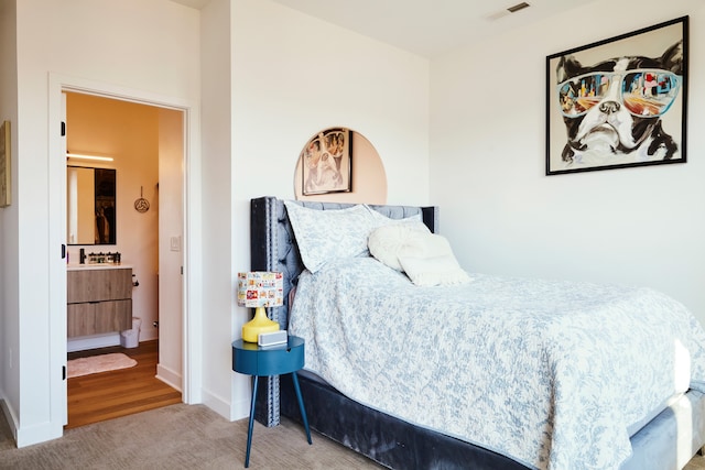 carpeted bedroom featuring ensuite bath