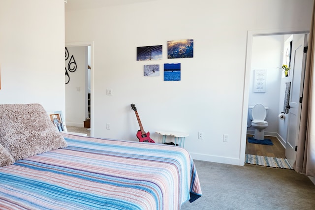 bedroom with connected bathroom and carpet flooring