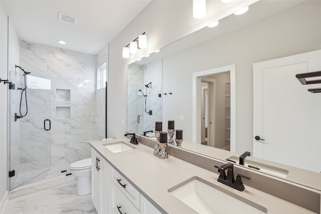 bathroom featuring a shower with door, vanity, and toilet