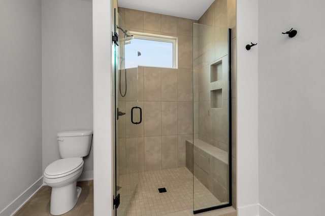 bathroom featuring toilet, tile patterned floors, and an enclosed shower