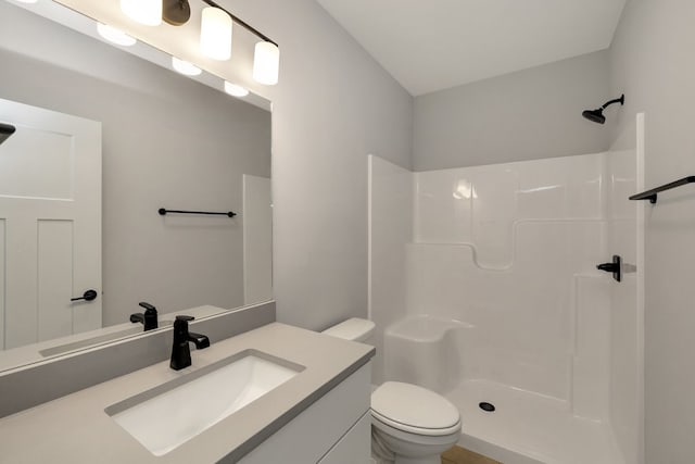 bathroom with toilet, walk in shower, and vanity