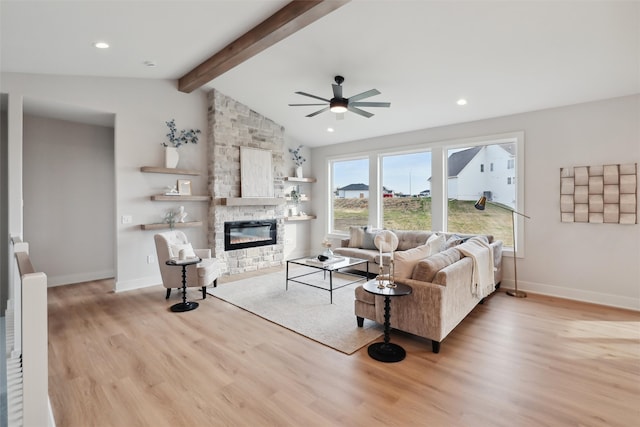 living room with light hardwood / wood-style floors, lofted ceiling with beams, a fireplace, and ceiling fan